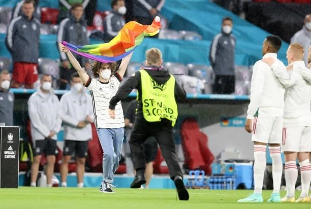 Fan is running on the field of play with a rainbow flag during the UEFA Euro 2020 Championship Group F match between Germany and Hungary at Allianz...