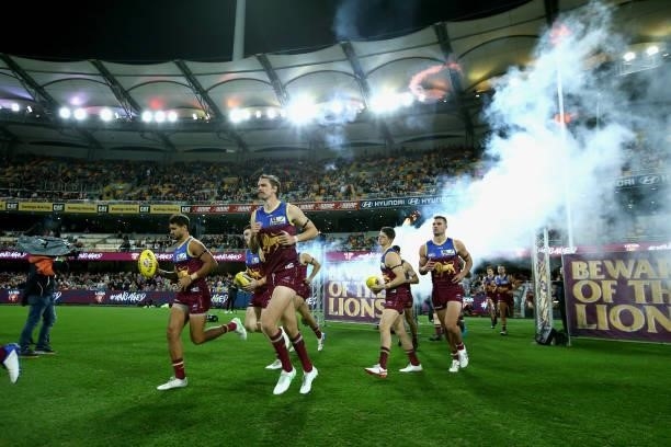 The Lions run out during the round 14 AFL match between the Brisbane Lions and the Geelong Cats at The Gabba on June 24, 2021 in Brisbane, Australia.