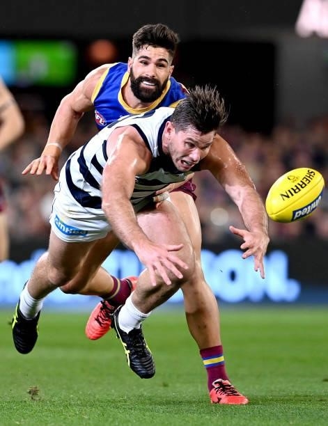 Tom Hawkins of the Cats is pressured by the defence during the round 14 AFL match between the Brisbane Lions and the Geelong Cats at The Gabba on...