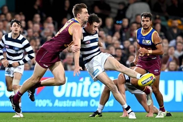 Jeremy Cameron of the Cats gets a kick away as he is pressured by the defence of Harris Andrews of the Lions during the round 14 AFL match between...
