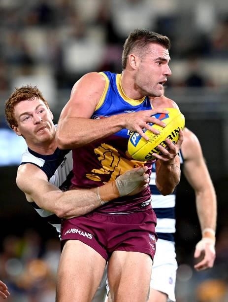 Jack Payne of the Lions is pressured by the defence of Gary Rohan of the Cats during the round 14 AFL match between the Brisbane Lions and the...