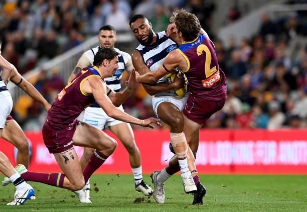 Esava Ratugolea of the Cats takes on the defence of Deven Robertson of the Lions during the round 14 AFL match between the Brisbane Lions and the...