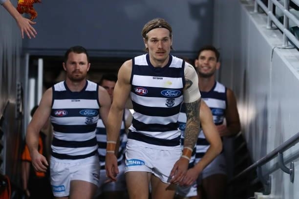 Tom Stewart of the Cats runs out for his 100th game during the round 14 AFL match between the Brisbane Lions and the Geelong Cats at The Gabba on...