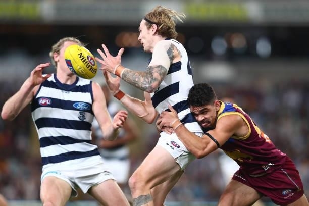 Tom Stewart of the Cats is tackled by Charlie Cameron of the Lions during the round 14 AFL match between the Brisbane Lions and the Geelong Cats at...