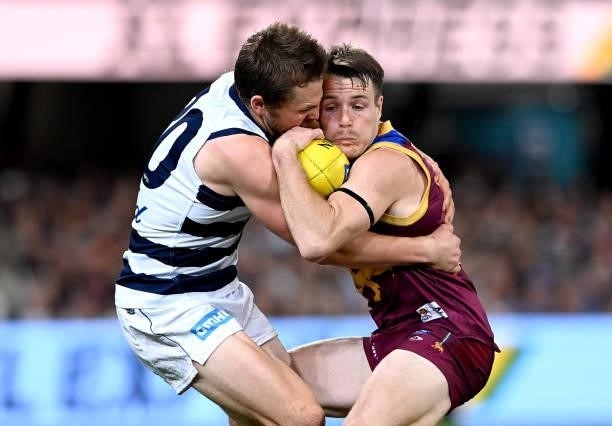 Lincoln McCarthy of the Lions is pressured by the defence of Tom Atkins of the Cats during the round 14 AFL match between the Brisbane Lions and the...