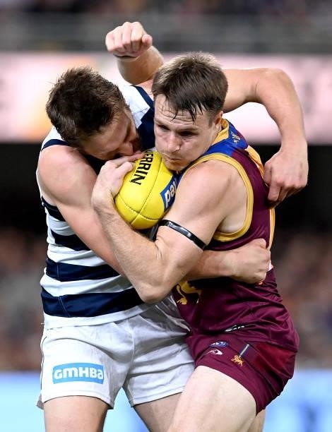 Lincoln McCarthy of the Lions is pressured by the defence of Tom Atkins of the Cats during the round 14 AFL match between the Brisbane Lions and the...