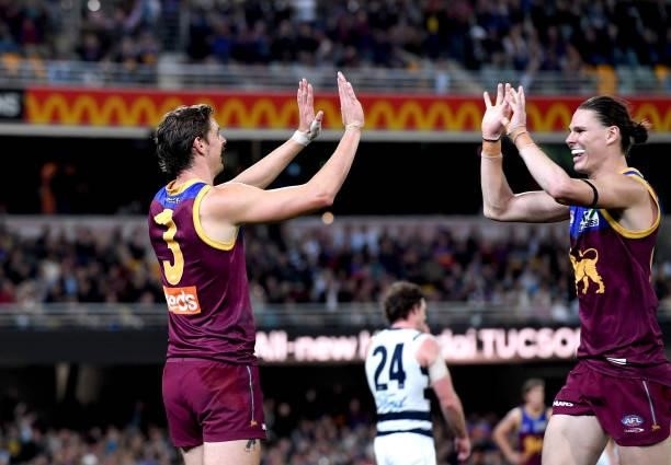 Joe Daniher of the Lions celebrates with team mates Eric Hipwood after kicking a goal during the round 14 AFL match between the Brisbane Lions and...