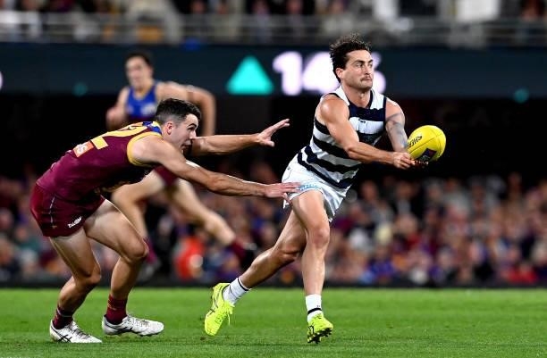 Luke Dahlhaus of the Cats gets a handball away during the round 14 AFL match between the Brisbane Lions and the Geelong Cats at The Gabba on June 24,...