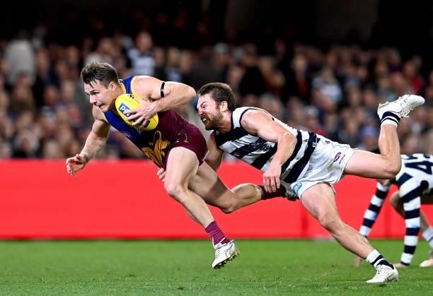 Lincoln McCarthy of the Lions breaks away from the defence of Tom Atkins of the Cats during the round 14 AFL match between the Brisbane Lions and the...