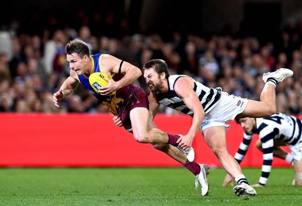 Lincoln McCarthy of the Lions breaks away from the defence of Tom Atkins of the Cats during the round 14 AFL match between the Brisbane Lions and the...
