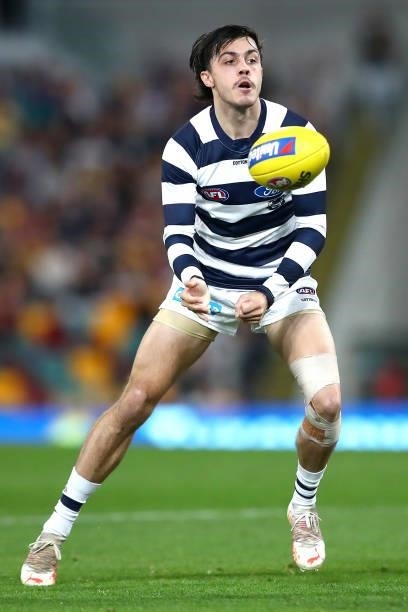 Bradley Close of the Cats handballs during the round 14 AFL match between the Brisbane Lions and the Geelong Cats at The Gabba on June 24, 2021 in...