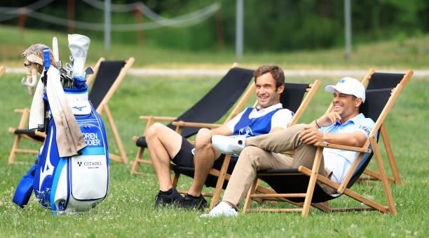 Adrien Saddier of France sits with his caddie during the first round of The BMW International Open at Golfclub Munchen Eichenried on June 24, 2021 in...