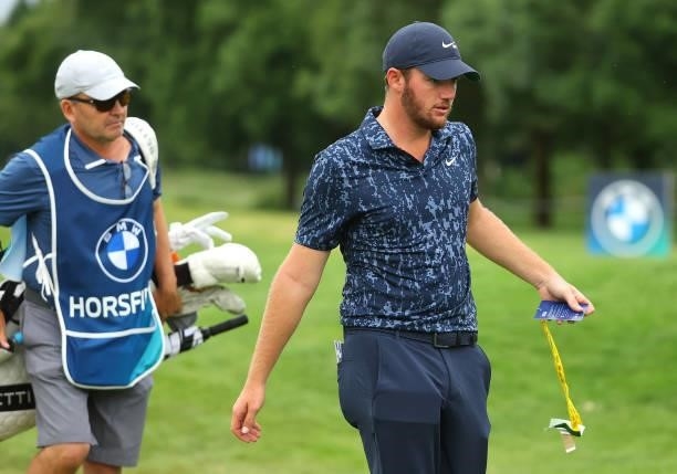 Sam Horsfield of England leaves the 18th green as the hooter sounds calling an end to play due to inclement weather during the first round of The BMW...