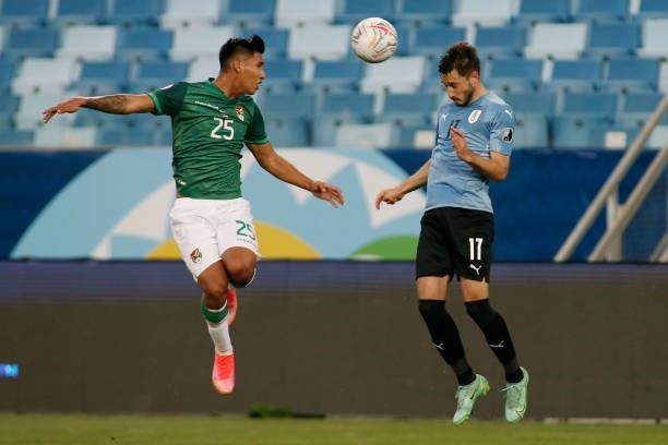 Matias Viña of Uruguay heads the ball against Jeyson Chura of Bolivia during a Group A match between Bolivia and Uruguay as part of Copa America...