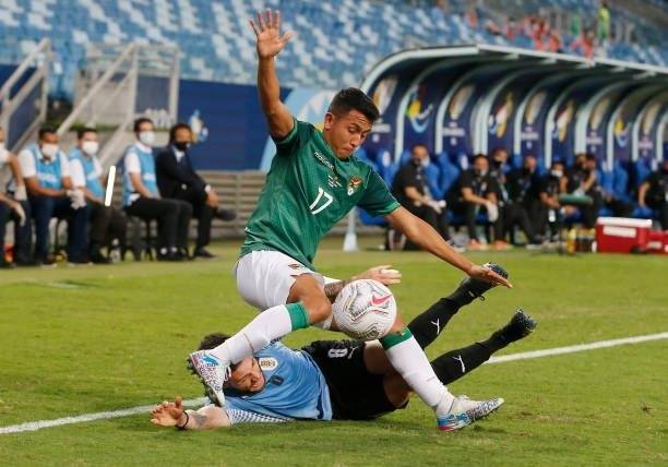 Roberto Fernandez of Bolivia fights for the ball with Nahitan Nandez of Uruguay during a Group A match between Bolivia and Uruguay as part of Copa...