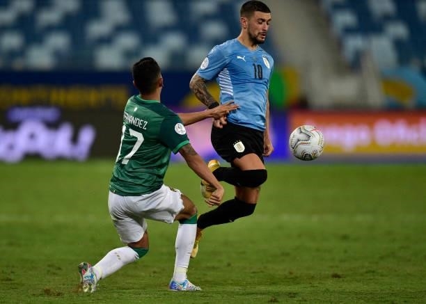 Giorgian De Arrascaeta of Uruguay jumps for the ball against Roberto Fernandez of Bolivia during a Group A match between Bolivia and Uruguay as part...