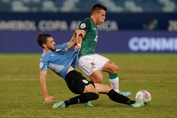 Henry Vaca of Bolivia fights for the ball with Matias Viña of Uruguay during a Group A match between Bolivia and Uruguay as part of Copa America...