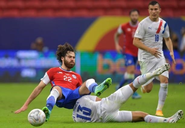 Ben Brereton of Chile and Alberto Espinola of Paraguay fall down as they fight for the ball during a Group A match between Chile and Paraguay as part...
