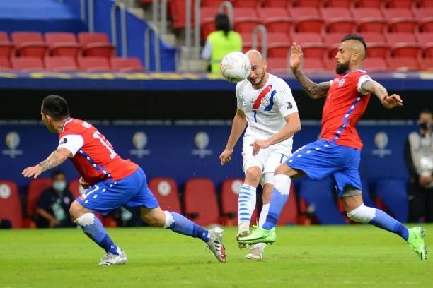 Carlos Gonzalez of Paraguay kicks the ball against Arturo Vidal of Chile during a Group A match between Chile and Paraguay as part of Copa America...