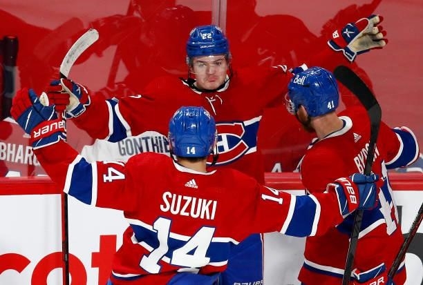Cole Caufield of the Montreal Canadiens celebrates with Nick Suzuki and Paul Byron after scoring a goal against Robin Lehner of the Vegas Golden...