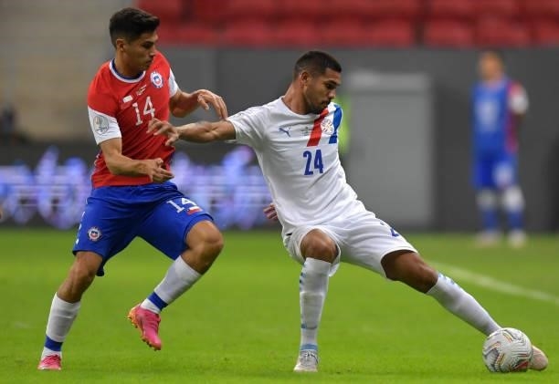 Hector Martinez of Paraguay fights for the ball with Pablo Galdames of Chile during a Group A match between Chile and Paraguay as part of Copa...