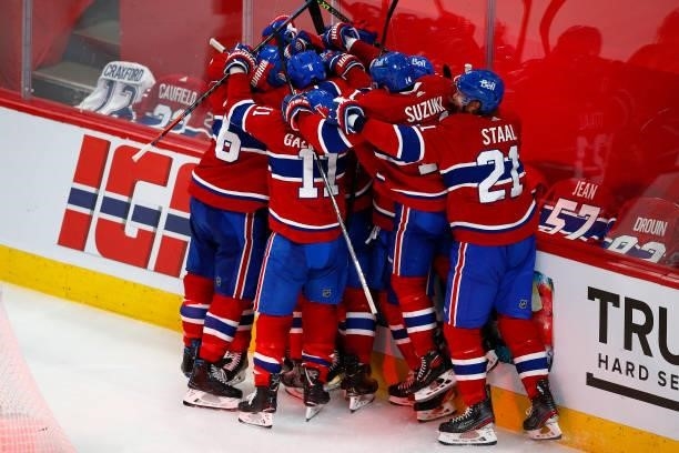Artturi Lehkonen of the Montreal Canadiens is congratulated by his teammates after scoring the game-winning goal during the first overtime period...