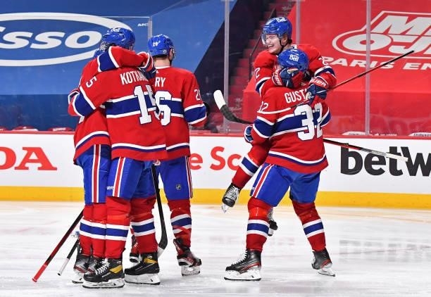 Cole Caufield of the Montreal Canadiens celebrates with his teammates after the game-winning overtime goal scored by Artturi Lehkonen against the...