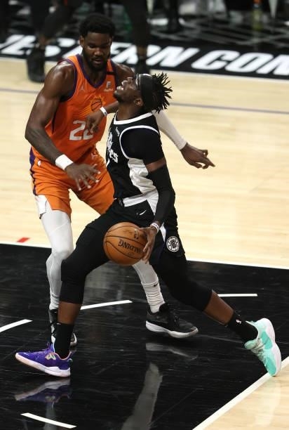 Reggie Jackson of the LA Clippers drives to the basket against Deandre Ayton of the Phoenix Suns during the second half of game three of the Western...