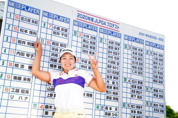 Juri Matsumoto of Japan points her name on the leaders board as she celebrates passing the professional test following the final round of the JLPGA...