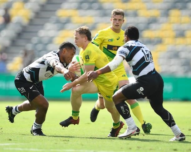 Henry Hutchison of Australia is tackled during the Oceania Sevens Challenge match between Fiji and Australia at Queensland Country Bank Stadium on...