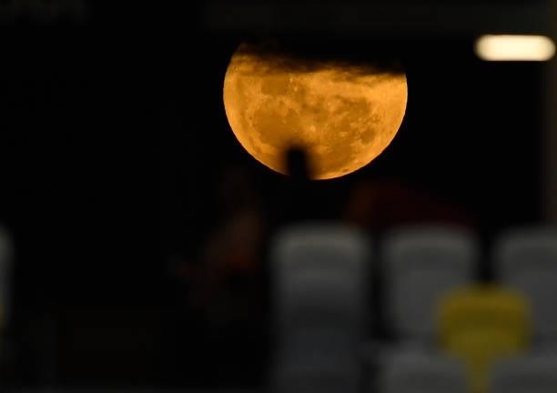 Spectators are seen silhouetted against the moon during the Oceania Sevens Challenge at Queensland Country Bank Stadium on June 25, 2021 in...