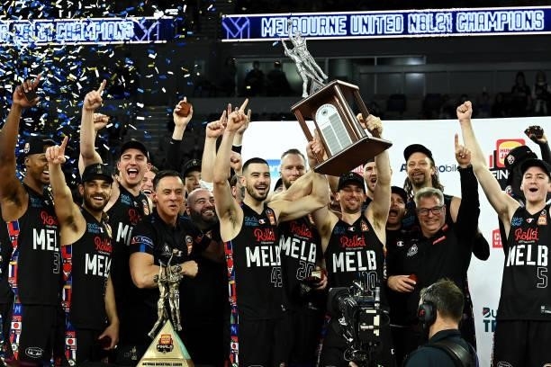 The Melbourne United team celebrate victory with the trophy after game three of the NBL Grand Final Series between Melbourne United and the Perth...