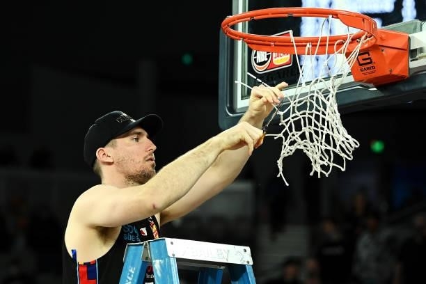 Mitch McCarron of Melbourne United cuts off the net as he celebrates victory after game three of the NBL Grand Final Series between Melbourne United...
