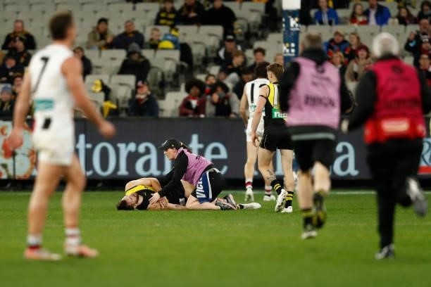 Noah Balta of the Tigers is helped by a trainer during the round 15 AFL match between the Richmond Tigers and the St Kilda Saints at Melbourne...