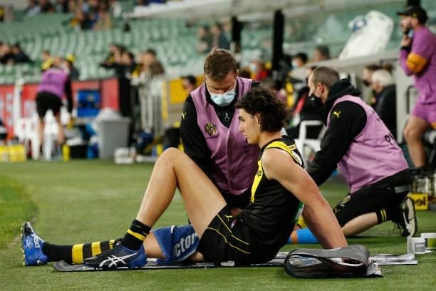 Samson Ryan of the Tigers is helped by a trainer during the round 15 AFL match between the Richmond Tigers and the St Kilda Saints at Melbourne...