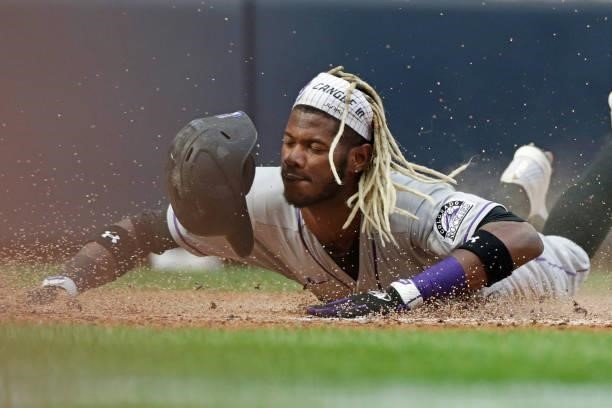 Raimel Tapia of the Colorado Rockies slides into home plate in the sixth inning against the Milwaukee Brewers at American Family Field on June 25,...