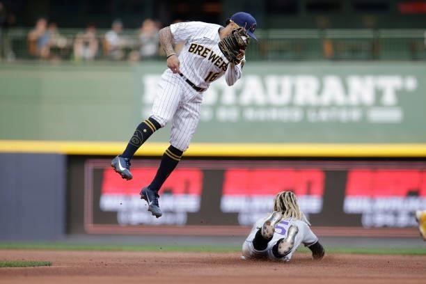 Kolten Wong of the Milwaukee Brewers jumps for the throw as Raimel Tapia of the Colorado Rockies steals second base in the sixth inning of the game...