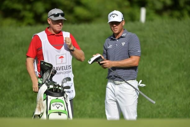 Talor Gooch of the United States talks with his caddie on the 14th hole during the second round of the Travelers Championship at TPC River Highlands...