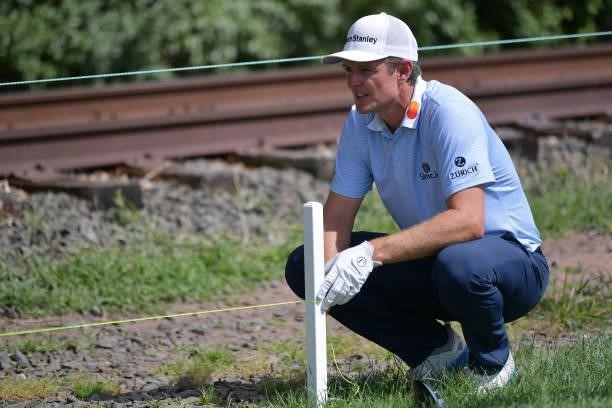 Justin Rose of England uses a strings to assess if his ball is in play or out of bounds on the 13th hole during the second round of the Travelers...