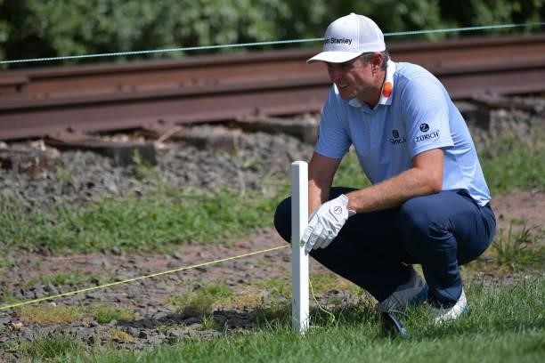 Justin Rose of England uses a strings to assess if his ball is in play or out of bounds on the 13th hole during the second round of the Travelers...