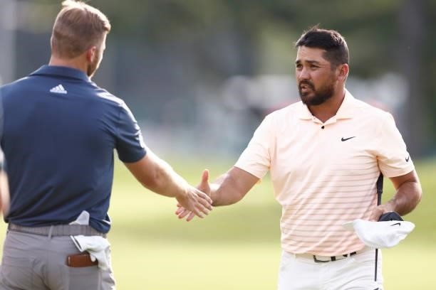 Jason Day of Australia shakes hands with Sam Burns of the United States after the finishing the second round of the Travelers Championship at TPC...