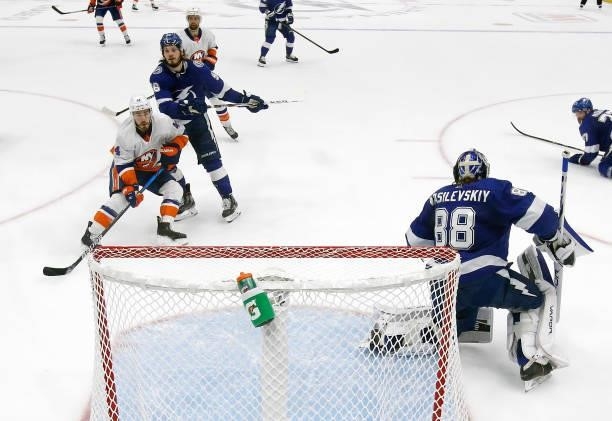 Jean-Gabriel Pageau of the New York Islanders is defended by Mikhail Sergachev of the Tampa Bay Lightning as Andrei Vasilevskiy tends net during the...