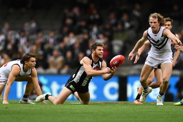 Taylor Adams of the Magpies handpasses during the round 15 AFL match between the Collingwood Magpies and the Fremantle Dockers at Marvel Stadium on...