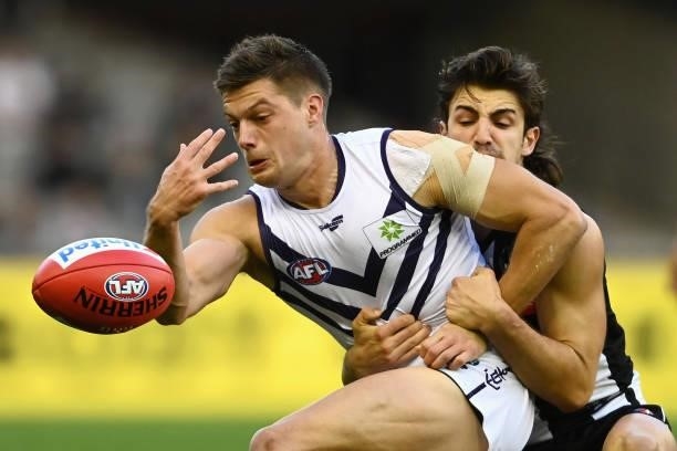 Darcy Tucker of the Dockers is tackled by Josh Daicos of the Magpies during the round 15 AFL match between the Collingwood Magpies and the Fremantle...