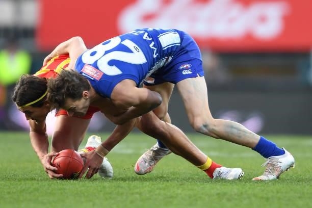 Kayne Turner of the Kangaroos and Wil Powell of the Suns compete for the ballduring the round 15 AFL match between the North Melbourne Kangaroos and...