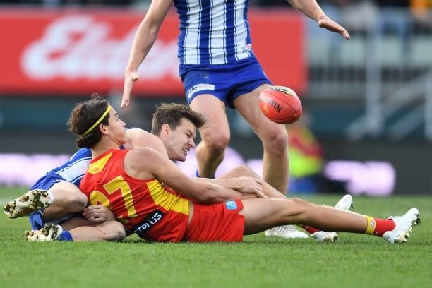 Kayne Turner of the Kangaroos and Wil Powell of the Suns compete for the ballduring the round 15 AFL match between the North Melbourne Kangaroos and...