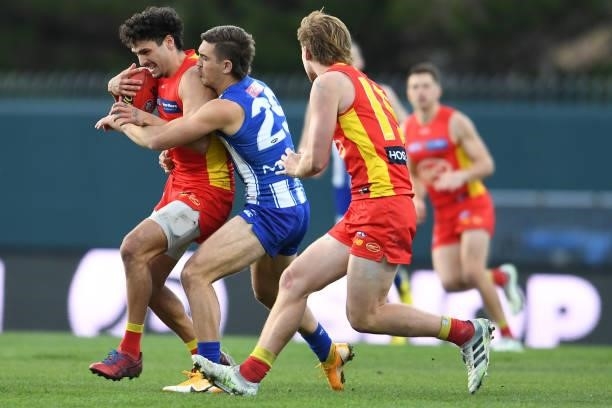 Izak Rankine of the Suns is tackled by Will Phillips of the Kangaroos during the round 15 AFL match between the North Melbourne Kangaroos and the...