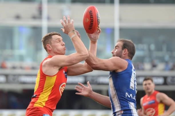 Nick Holman of the Suns and Ben Cunnington of the Kangaroos compete for the ball during the round 15 AFL match between the North Melbourne Kangaroos...