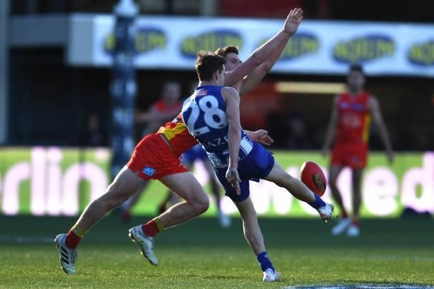 Noah Anderson of the Suns tries to smother the kick of Kayne Turner of the Kangaroos during the round 15 AFL match between the North Melbourne...