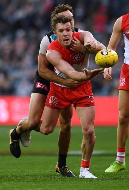 Luke Parker of the Swans handballs tackled by Steven Motlop of Port Adelaide during the round 15 AFL match between the Port Adelaide Power and the...